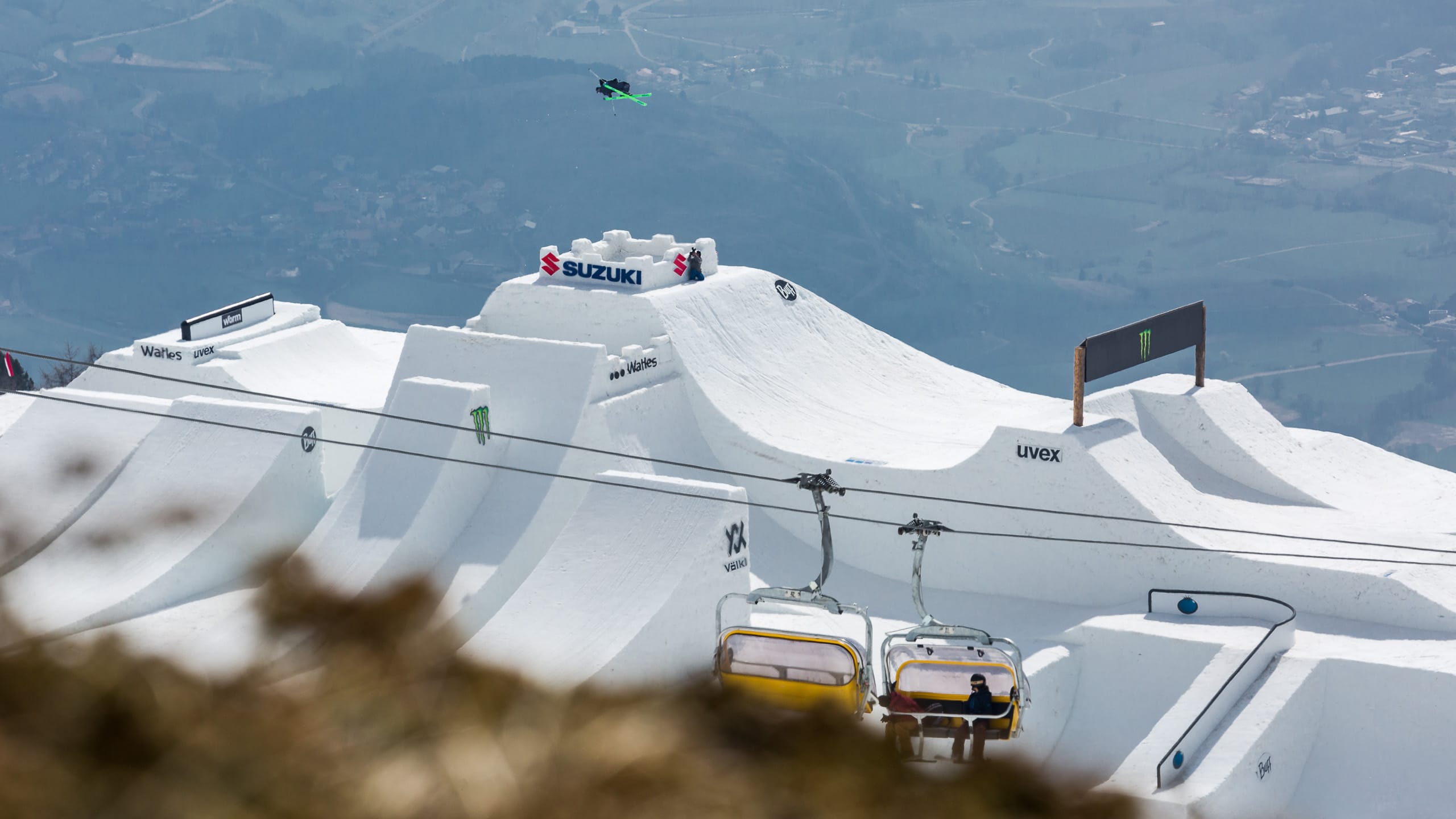 Ein Ski Slopestyler springt einen Kicker.