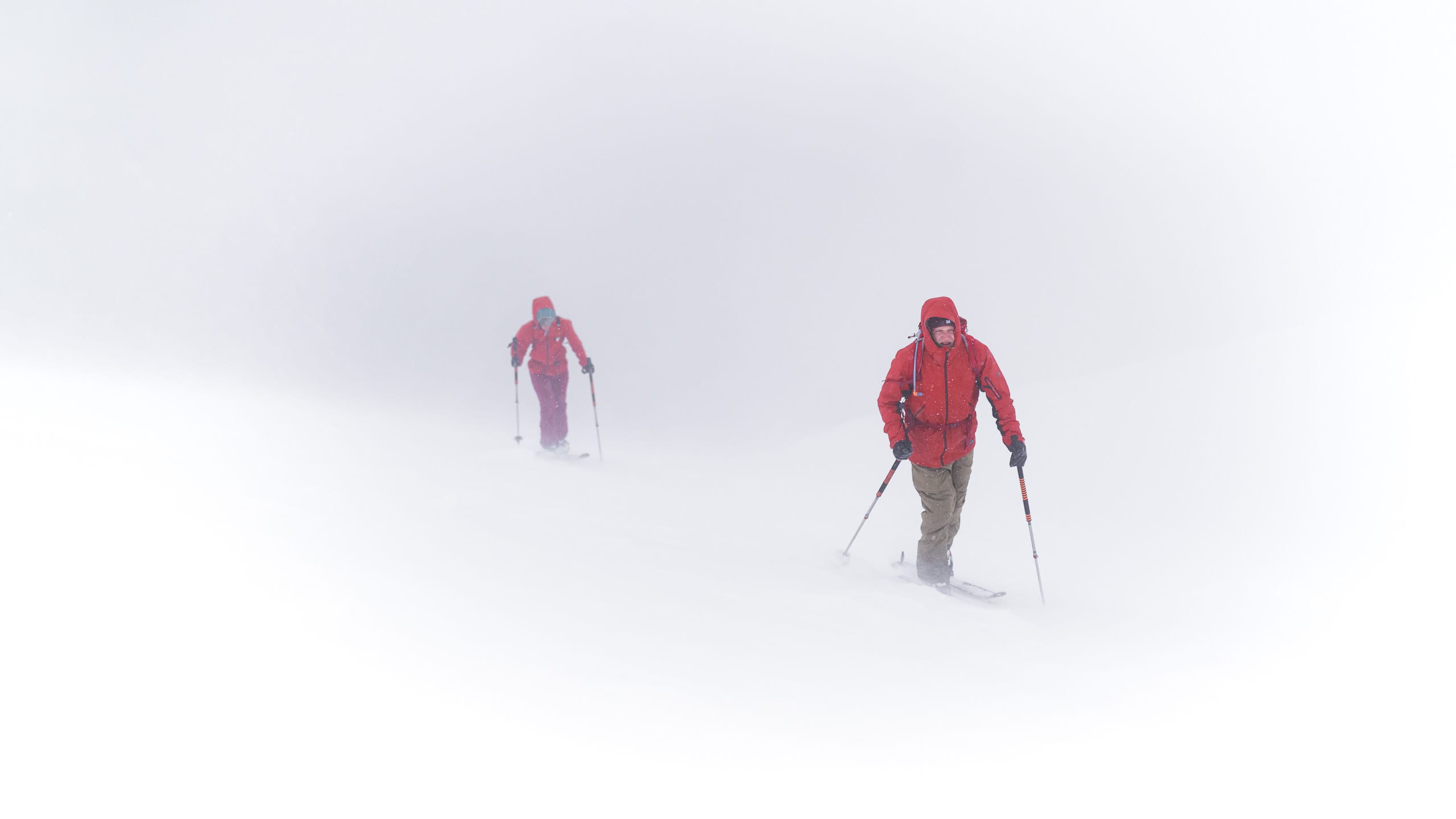 Zwei Skitourengeher:innen im Nebel.