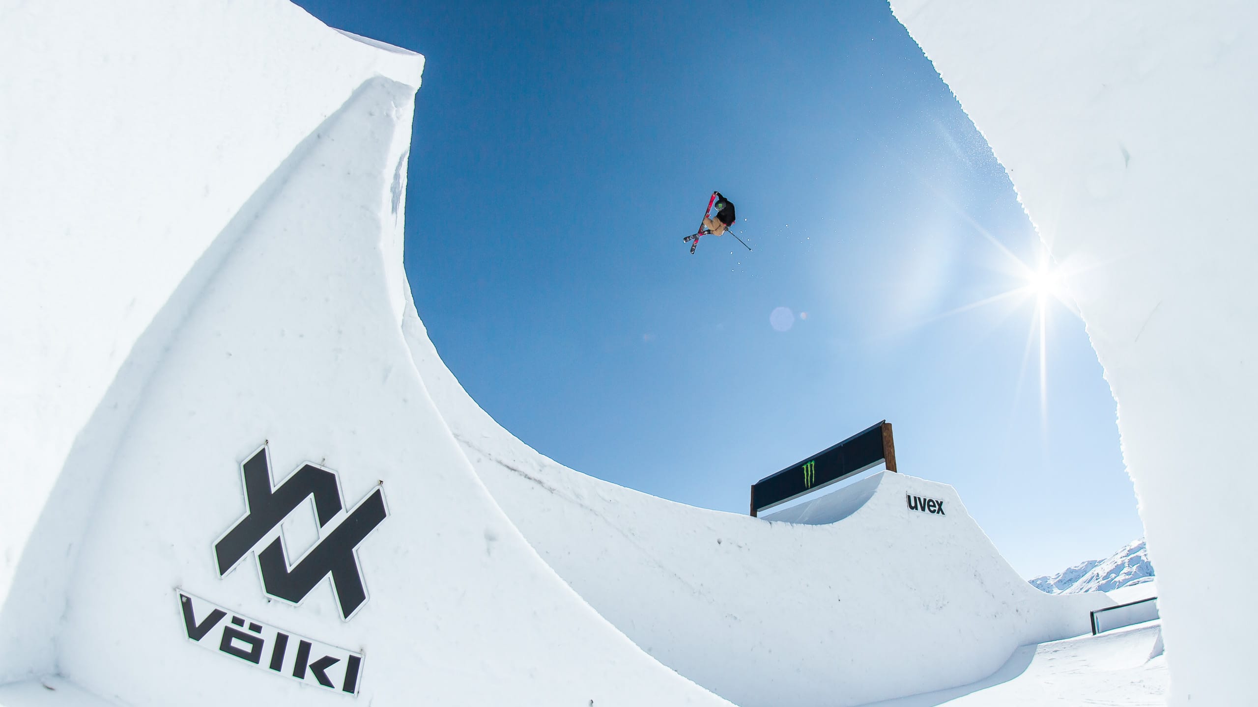 Ein Ski Slopestyler fliegt über einen Kicker.